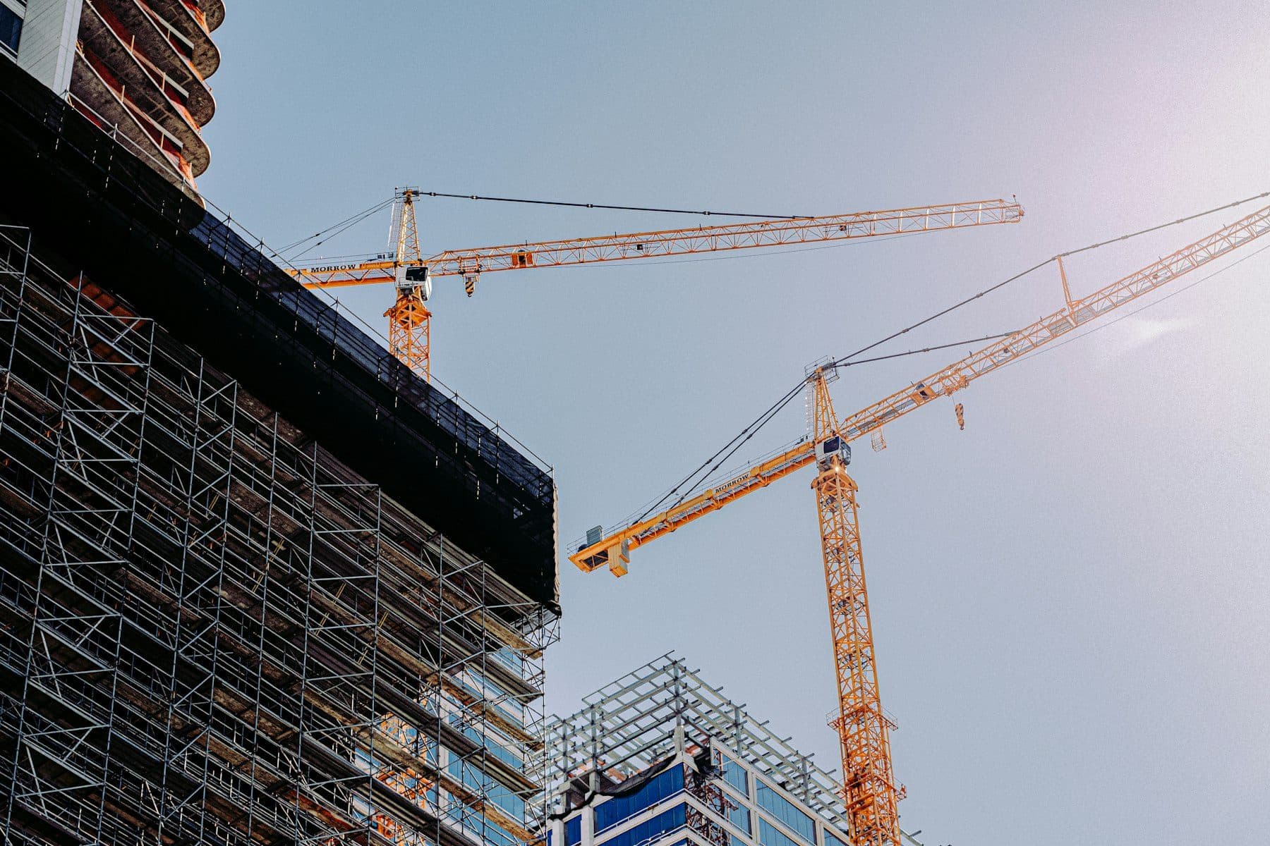 Cranes and scaffolding over a building under construction.