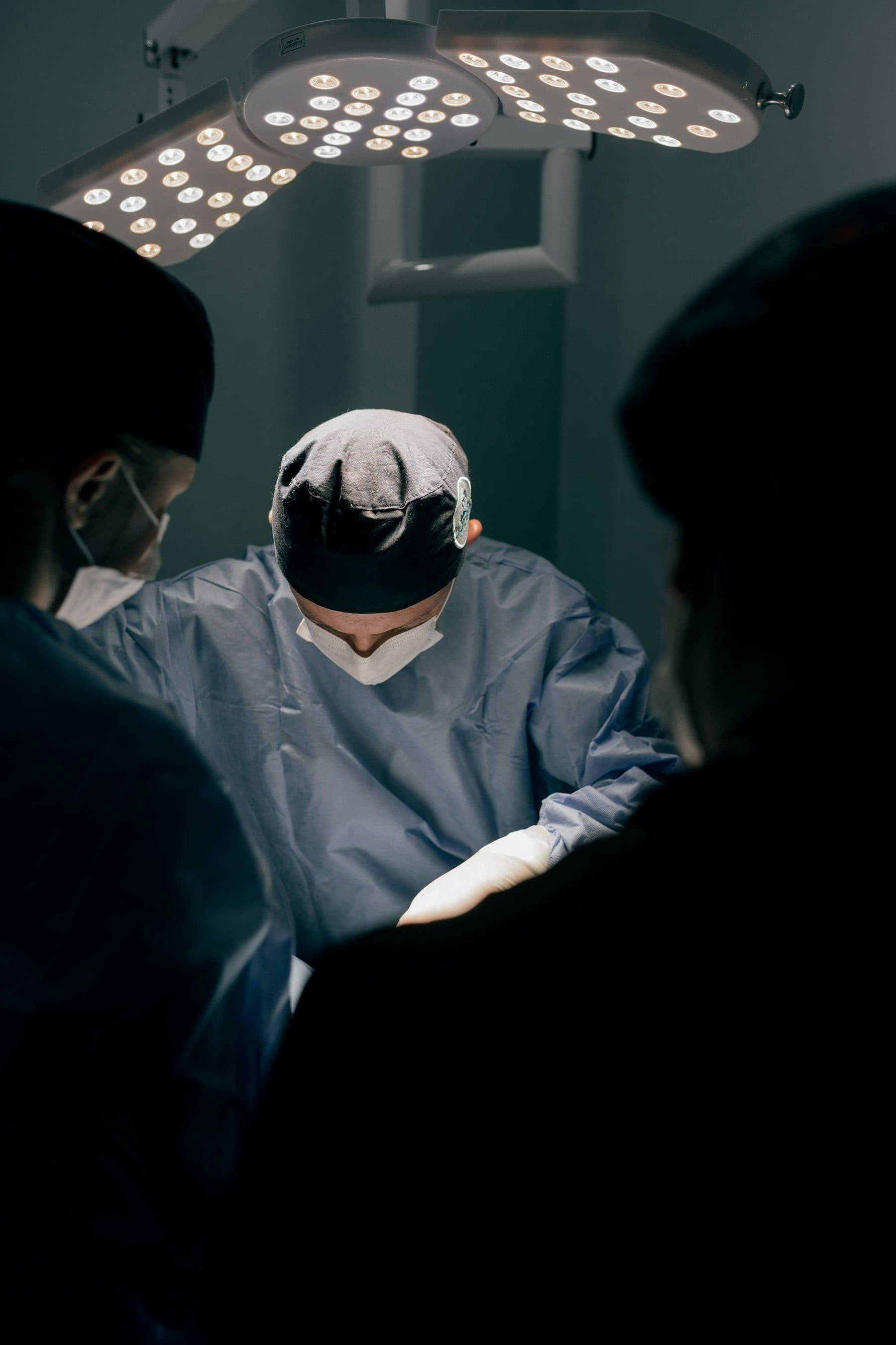 A surgical team at work beneath an operating theatre lamp.