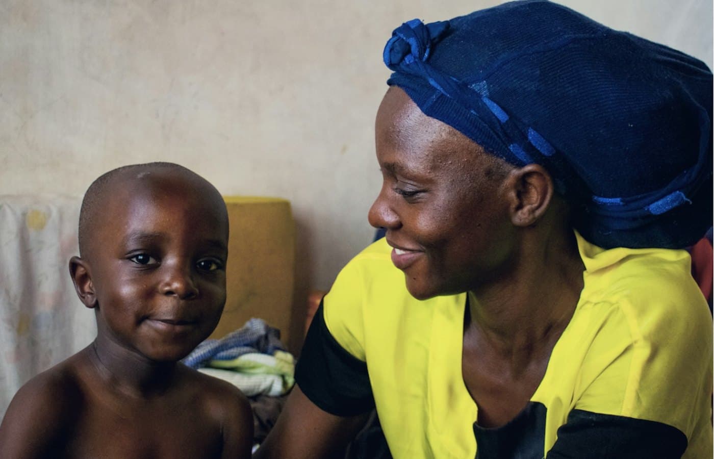 A young child sits beside their mother, both at ease. Paediatric and neonatal intensive care are planned services at TEMCO, opening 2029.