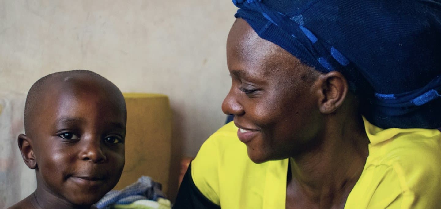 A mother looks at her young child, who is smiling. Maternity, neonatal and children's care are planned services at TEMCO, opening 2029.