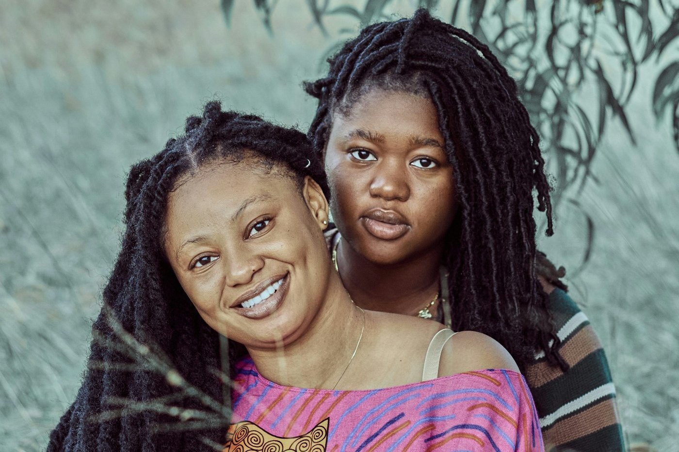 A woman and her teenage daughter stand together, both smiling. Women's health, maternity and fertility care are planned services at TEMCO, opening 2029.